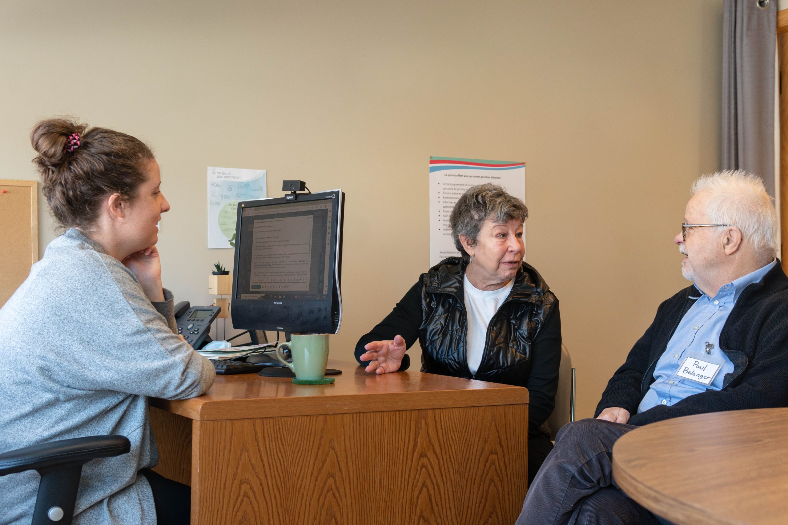 une éducatrice répondant aux questions d'un proche aidant et de son proche aidé